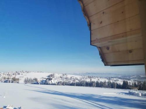 a view of a snow covered field from a cabin at Zymbiańsko Chałupa 1 z balią na wyłączność in Ząb