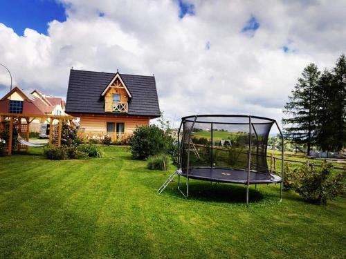 a trampoline in a yard in front of a house at Zymbiańsko Chałupa 1 z balią na wyłączność in Ząb