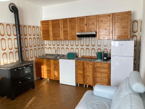 uma cozinha com armários de madeira e um frigorífico branco em Casa vacanze Fregè em Castione Andevenno