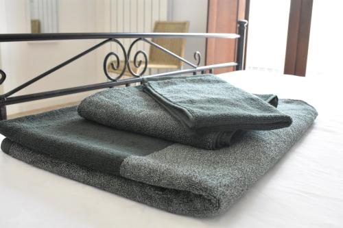una pila de toallas sentadas encima de una cama en Le Radici Home en LʼAquila