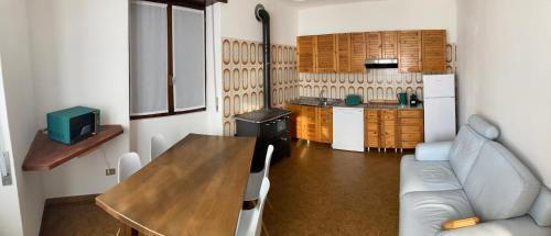 a kitchen with a table and a couch in a room at Casa vacanze Fregè in Castione Andevenno