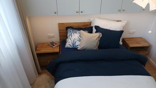 1 dormitorio con 1 cama con sábanas y almohadas azules en Apartament Sztygara, en Mikołów