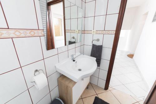 La salle de bains est pourvue d'un lavabo et d'un miroir. dans l'établissement Apartman Mihelčić, à Delnice