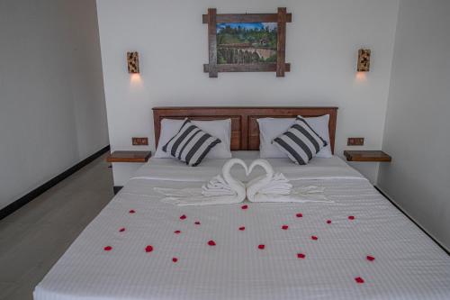 a bedroom with a bed with red roses on it at Eagle View villa in Ella