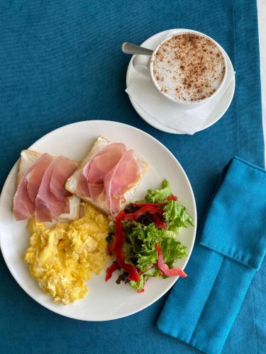 a plate of food with eggs and ham and a cup of coffee at FENIX TOWN in Vinnytsya