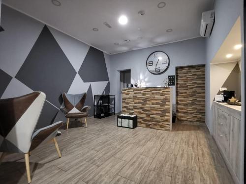 a room with chairs and a clock on the wall at Re Carlo Rooms in Catania