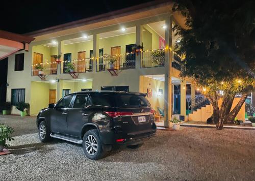 a black suv parked in front of a building at Hotel La Fiore de Bahia in Uvita