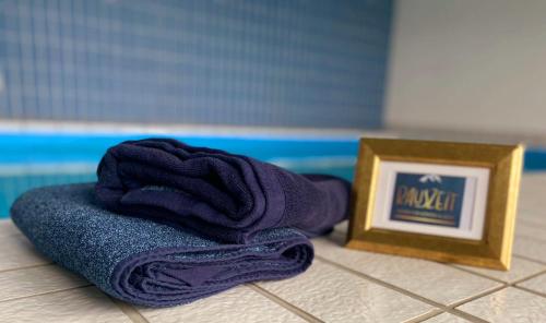 a towel and a picture next to a picture frame at Traum-Maisonette auf 1.000m mit Pool und Sauna in Schönwald