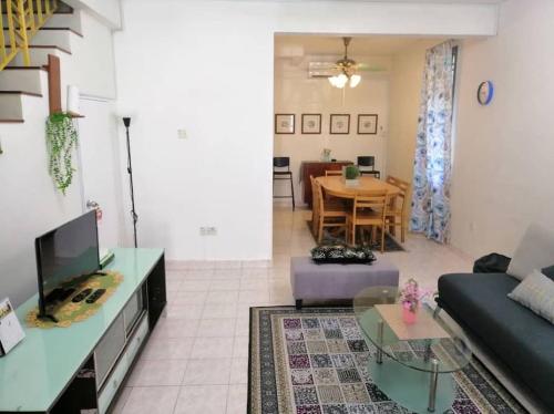a living room with a couch and a table at Cozy house with free wifi and parking near Utm, Legoland in Skudai