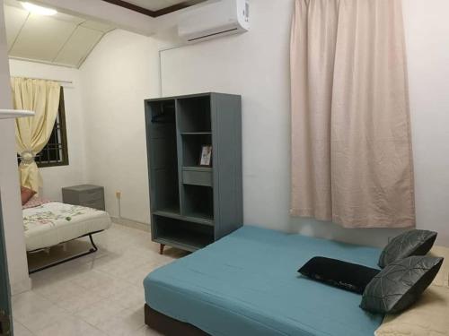 1 dormitorio con 1 cama azul en una habitación en Cozy house with free wifi and parking near Utm, Legoland, en Skudai