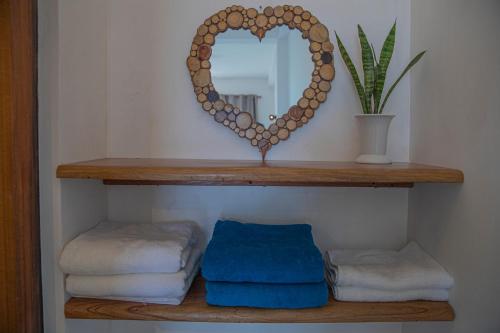 a shelf with a heart mirror and towels at Eagle View villa in Ella