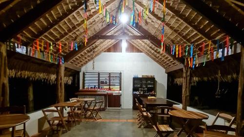 un comedor con mesas, sillas y banderas en Casa Saimiri, en Alter do Chao