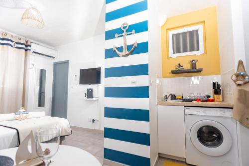 uma casa de banho com uma parede listrada em azul e branco em Le petit marin des salines à 0 metre de la plage em Montjoly