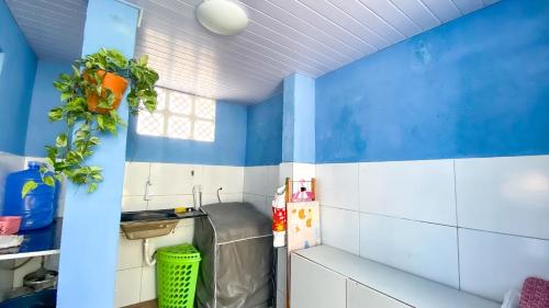 a kitchen with blue walls and white tiles at Linda Casa na Praia dos Carneiros,1 Minuto do Mar, Piscina Spa e Todo o Conforto in Praia dos Carneiros