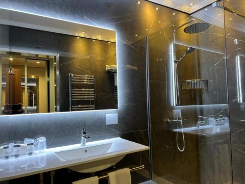 a bathroom with a sink and a shower and a mirror at Hotel Comillas in Comillas