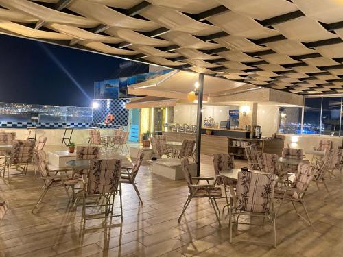 Un restaurante con sillas y mesas y un bar. en ALENA HOTEL, en Áqaba