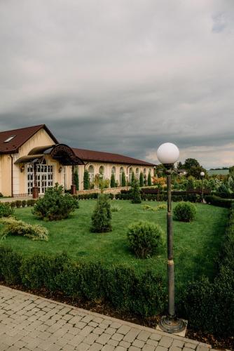 a house with a lamp post in the middle of a yard at Готельно-ресторанний комплекс Прованс парк in Pochayiv
