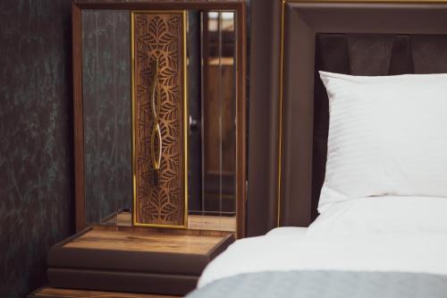 a bedroom with a mirror next to a bed at Hotel Premium in Pristina