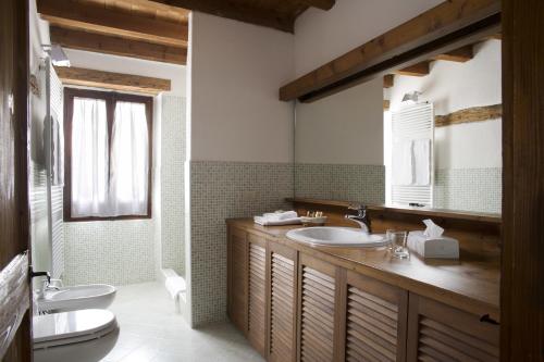 bagno con lavandino, servizi igienici e specchio di Il Relais dell'Abbazia a Verona