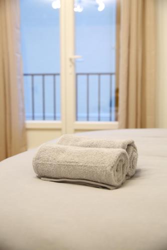 Una toalla sentada en una cama frente a una ventana en Paris: agréable chambre d’un grand artiste en París