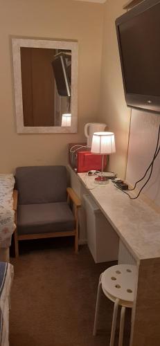 a room with a desk with a television and a chair at Delightful home stay - Double ensuiteroom. in Glasgow