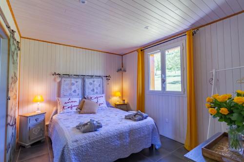 een slaapkamer met een bed en een vaas met bloemen bij CHALET DU REV'EAUBOIS in Larche