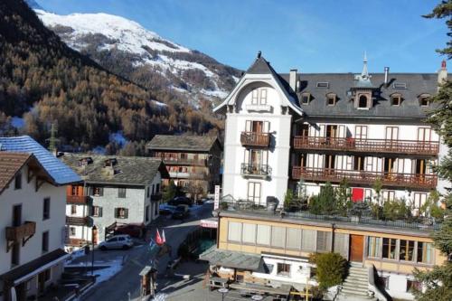 un gran edificio blanco en una ciudad con una montaña en Studio cosy au centre du village, en Evolène