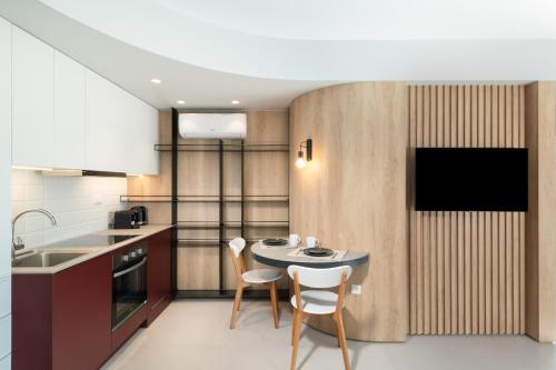 een keuken met een tafel en stoelen in een kamer bij Evans Luxurious Apartment 2 in Heraklion