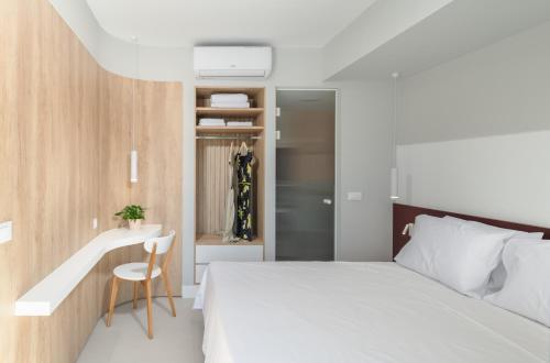 a bedroom with a white bed and a desk at Evans Luxurious Apartment 2 in Heraklio