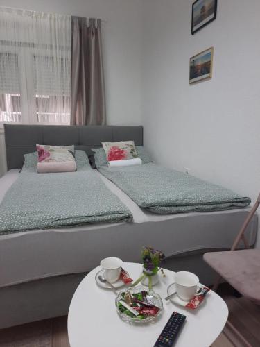 a bedroom with a large bed with a coffee table at Apartman Square in Mostar