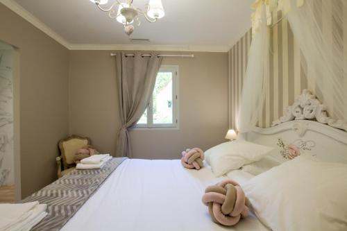 a bedroom with a white bed with stuffed animals on it at Gîte Spa & Nature in Saint-Chamassy