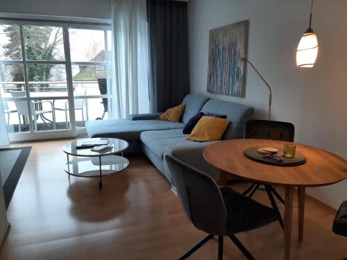 a living room with a blue couch and a table at Haus Seeblick mit PKW-Stellplatz am Haus in Überlingen