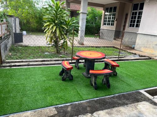 a table and four chairs on a green lawn at warisan gp homestay in Kuala Terengganu