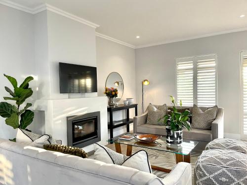 a living room with a couch and a fireplace at The Village Cottage in Franschhoek