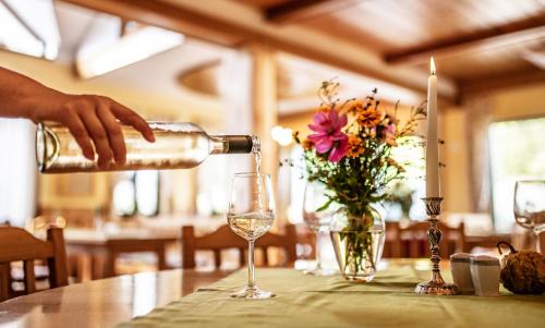 a person pouring wine into a glass on a table at Der Winzerhof in Achau