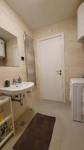 uma casa de banho com uma porta branca e um lavatório em Sleek & lovely studio with a great location em Belgrado