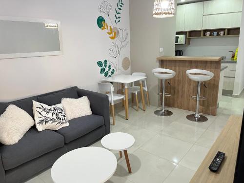 uma sala de estar com um sofá e mesas e uma cozinha em DEPARTAMENTO CENTRICO em Bahía Blanca