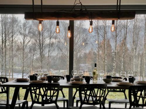 a table with chairs and wine glasses in front of a window at BosaRosa - domki nad zalewem in Wünschelburg