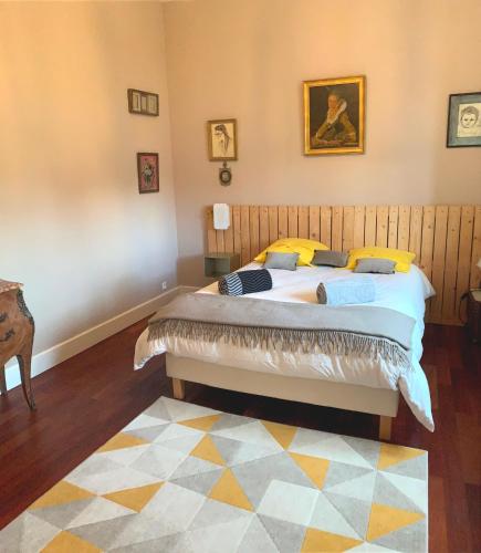 a bedroom with a large bed with yellow pillows at Suite privative Abella - Aile de maison bourgeoise in Ambarès-et-Lagrave