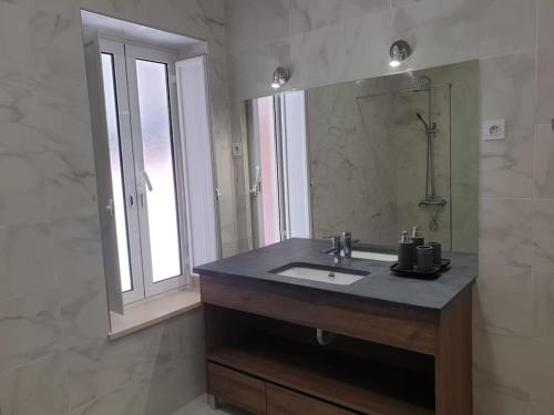 a bathroom with a sink and a mirror at Casa do Moleiro in Mortágua