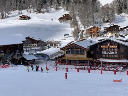 a group of people standing in the snow in front of a ski lodge at Le Schuss in Châtel