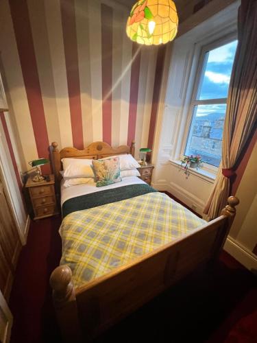 a small bedroom with a bed with a window at Rosehall Hotel in Edinburgh