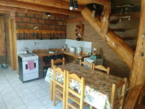 a kitchen with a table and a stove at Murmullos del bosque in Lago Puelo