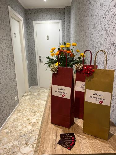 two shopping bags and flowers on a table at B&B Baciami Ancora in Bari