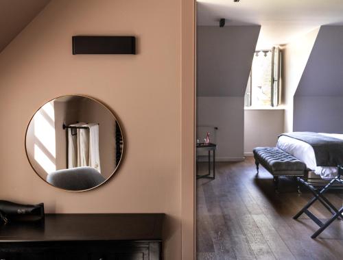 a bedroom with a round mirror and a bed at Chateau De Germigney in Port-Lesney