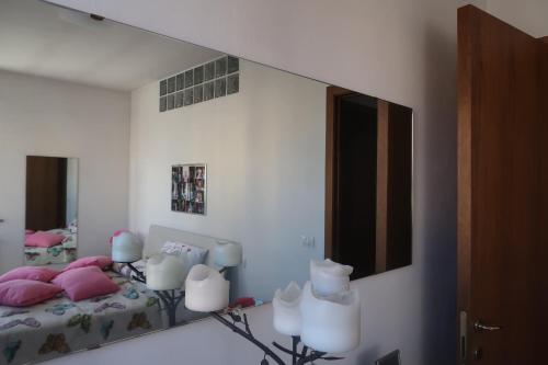 a bedroom with a mirror and a bed with pink pillows at La casa di Ale in Arezzo