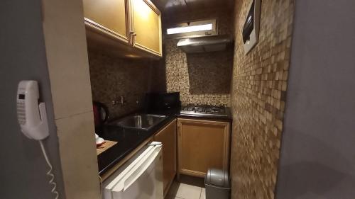 a small kitchen with a sink and a stove at Tropicana Beach & Resort in Elwa
