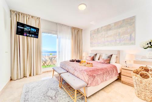 sypialnia z łóżkiem i dużym oknem w obiekcie Black Beach Luxury Vacation House w mieście Puerto de Santiago