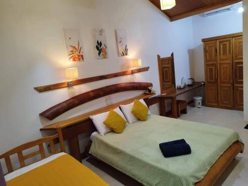 1 dormitorio con 1 cama con cabecero de madera en Reethi Villa Vaavu Thinadhoo, en Thinadhoo