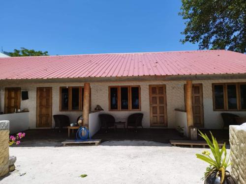 una pequeña casa con techo rojo en Reethi Villa Vaavu Thinadhoo, en Thinadhoo